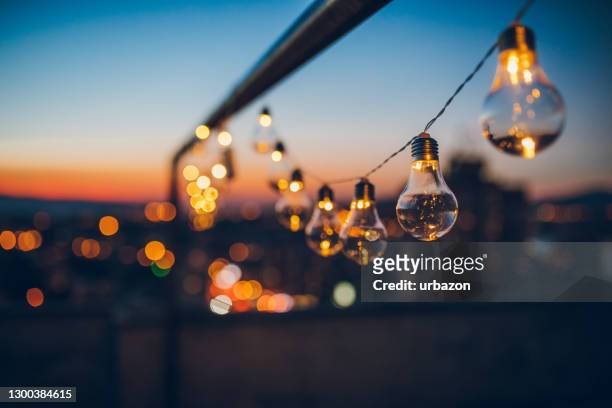 string light bulbs at sunset - night stock pictures, royalty-free photos & images