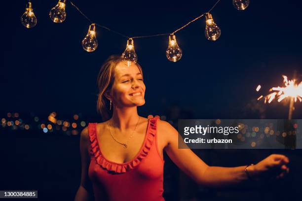 with sparkler on the rooftop - décolleté stock pictures, royalty-free photos & images