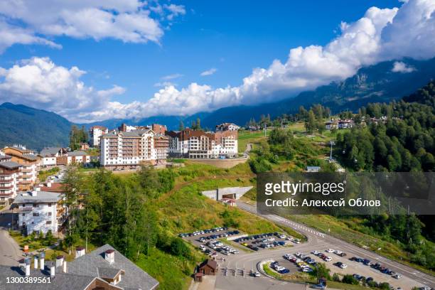summer aerial view of the ski resort rosa khutor. a complex of hotels on the site of the former olympic village of rosa plateau at an altitude of 1170 m from sea level. krasnaya polyana, sochi, russia - krasnaya polyana sochi fotografías e imágenes de stock