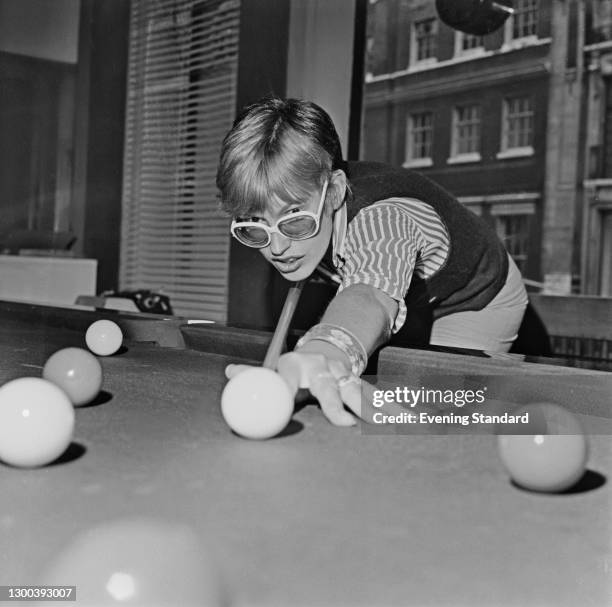 English broadcaster and journalist Janet Street-Porter, fashion editor of the Evening Standard newspaper, during a game of snooker, UK, 5th August...