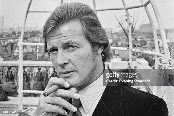 English actor Roger Moore on the roof of the Dorchester Hotel in London, UK, 2nd August 1972. He is there with producers Albert R. Broccoli and Harry...