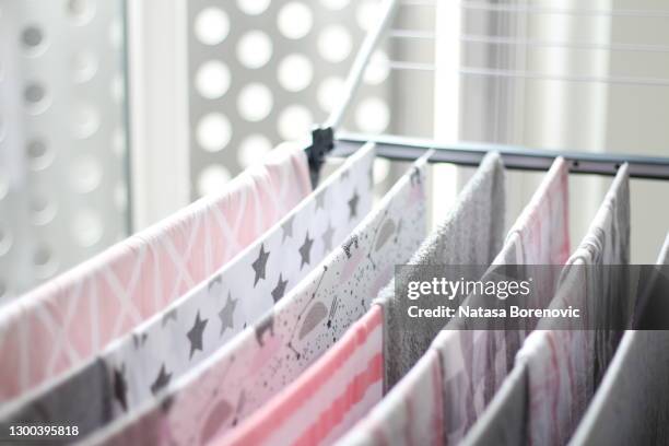 close up of pink, grey and white laundry and clothes hanging on drying rack - drying stock pictures, royalty-free photos & images