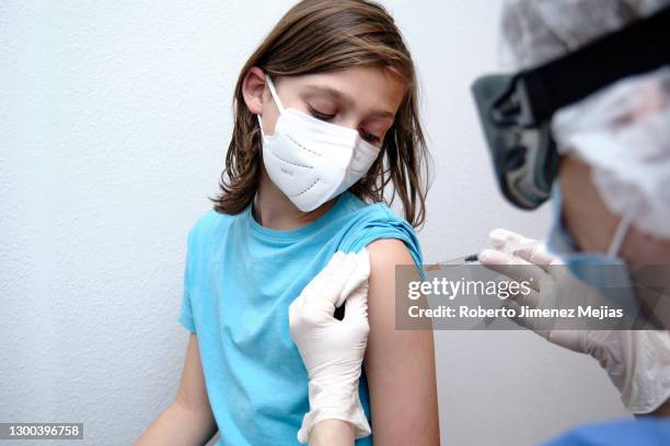 female doctor giving covid-19 vaccine to a boy - child vaccination stock pictures, royalty-free photos & images