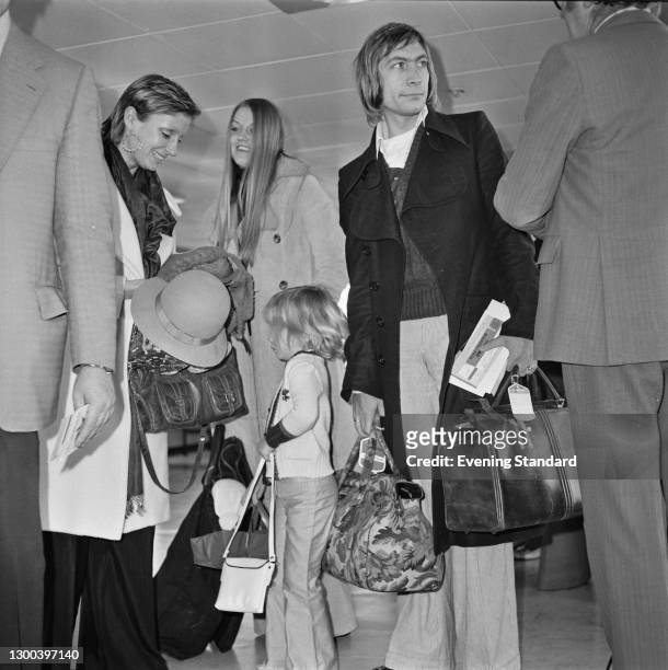 English drummer Charlie Watts of rock group the Rolling Stones at Heathrow Airport in London with his wife Shirley and their daughter Seraphina, UK,...