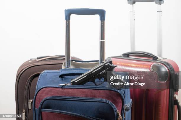 gun in a travel suitcase. - covid politics stock pictures, royalty-free photos & images