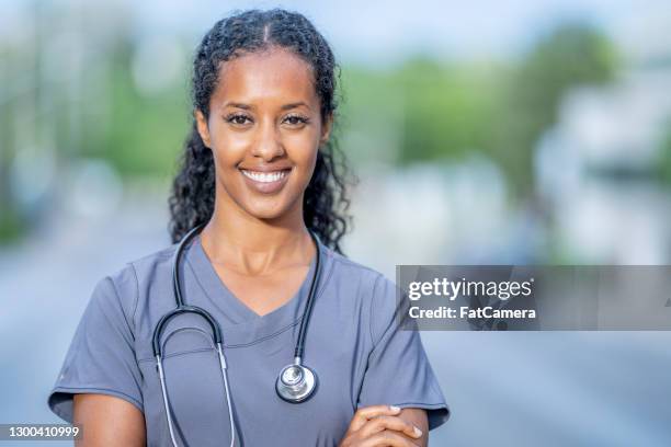 portrait of female nurse standing outside the hospital - resident stock pictures, royalty-free photos & images