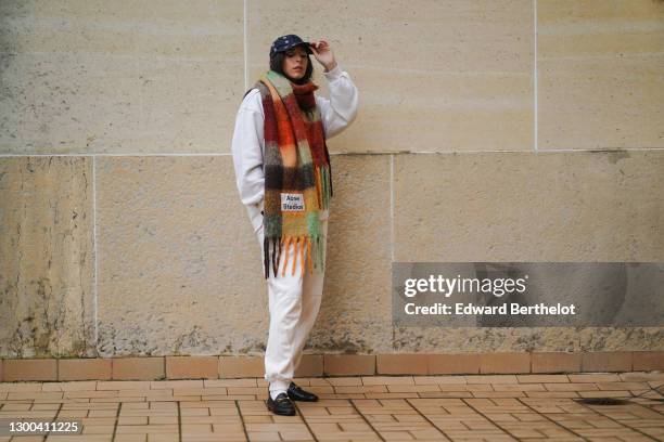 Gabriella Berdugo wears a Calvin Klein outfit made of beige sweat / jogger sportswear pants and a white oversized sweat shirt, white socks, Gucci...