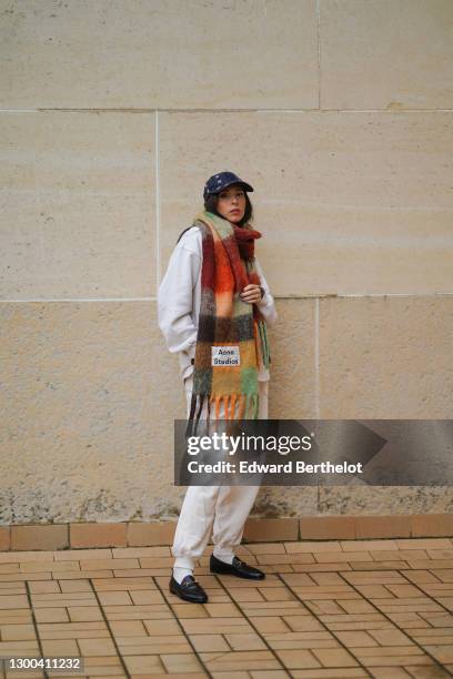 Gabriella Berdugo wears a Calvin Klein outfit made of beige sweat / jogger sportswear pants and a white oversized sweat shirt, white socks, Gucci...