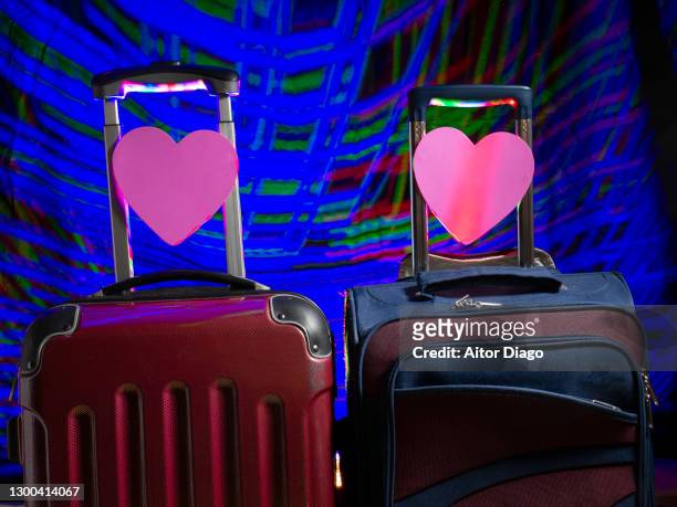 two suitcases with pink hearts. futuristic photo with an internet inspired background representing the concept of dating agency to find love. - speed dating stockfoto's en -beelden