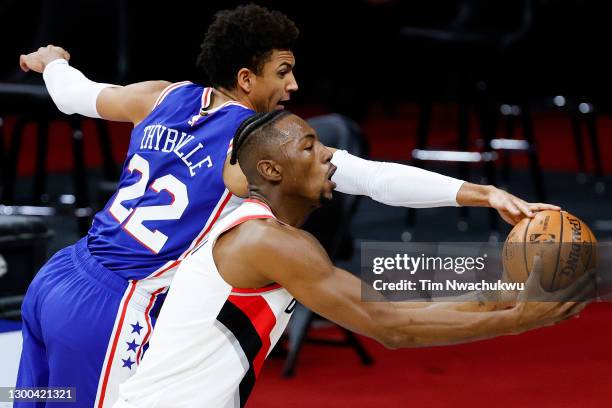 Matisse Thybulle of the Philadelphia 76ers and Harry Giles III of the Portland Trail Blazers reach for the ball during the second quarter at Wells...