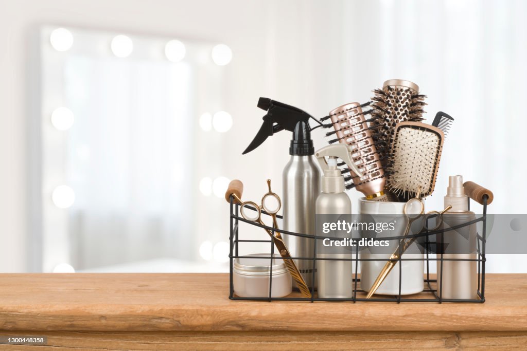 Hairdresser tools on wooden table with blurred beauty salon background