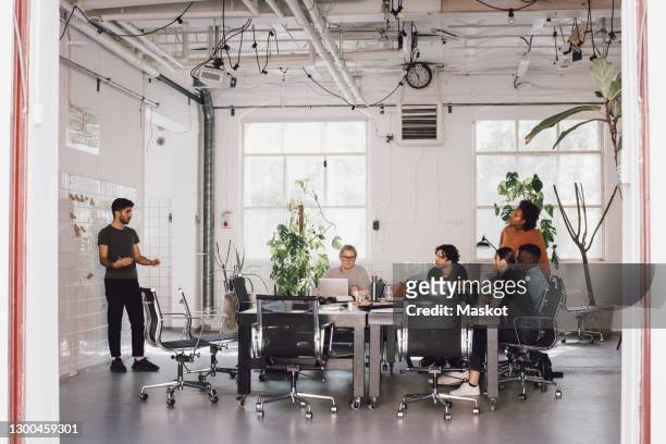 young it computer programmer explaining colleagues in meeting at office - new business stock pictures, royalty-free photos & images