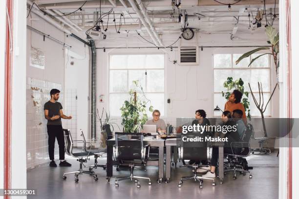 young it computer programmer explaining colleagues in meeting at office - start up office imagens e fotografias de stock