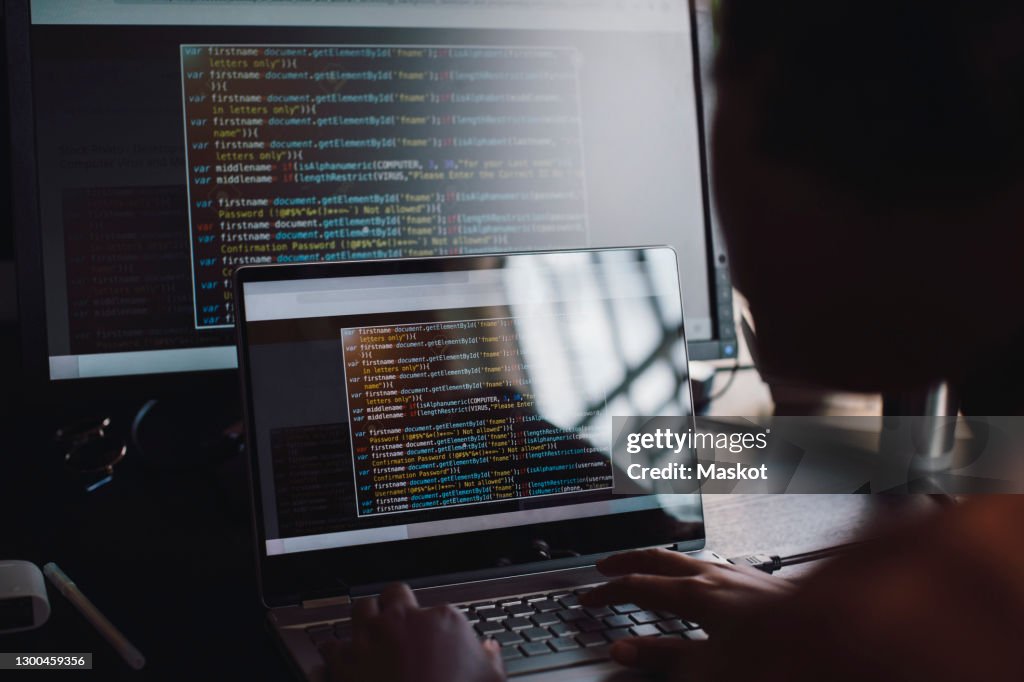 Young female engineer coding over laptop in IT startup company