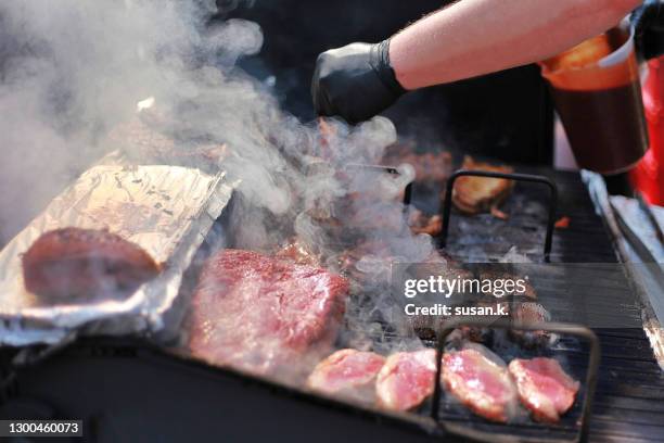 close up shot of cook grilling smoking beef steak outdoors. - smoked stock pictures, royalty-free photos & images