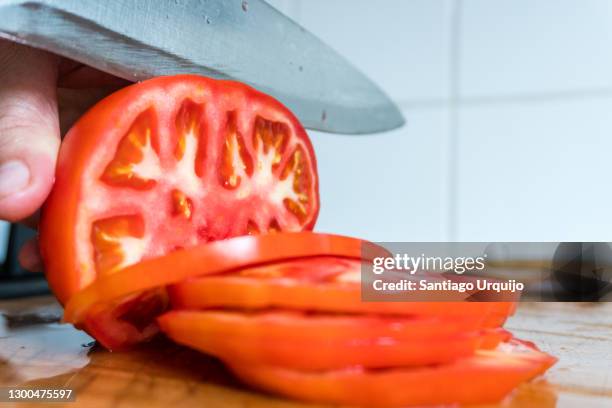 cutting tomatoes slices - tomate fotografías e imágenes de stock