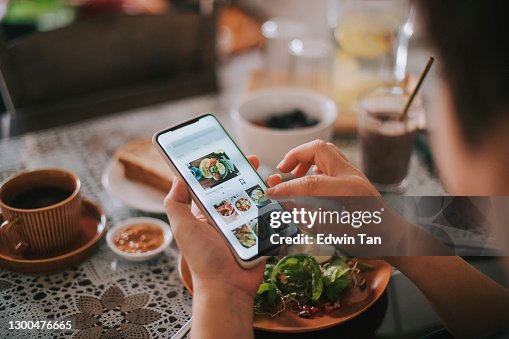 High angle view asian chinese woman's hand on mobile app for online food delivery during breakfast time High angle view asian chinese woman's hand on mobile app for online food delivery during breakfast time