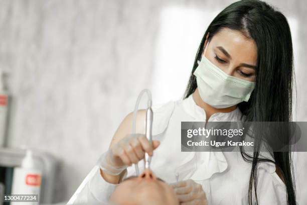 the cosmetologist makes the procedure microcurrent therapy of the facial skin - capillary body part stock pictures, royalty-free photos & images