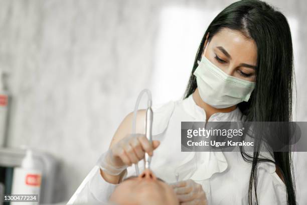 o cosmetologista faz o procedimento microcorrente terapia da pele facial - terapeuta de beleza - fotografias e filmes do acervo