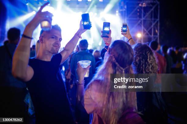 junge leute auf musikfestival mit smartphones und filmen - drinking beer festival stock-fotos und bilder