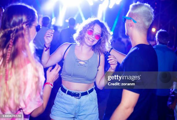 junge frau mit roter sonnenbrille mit freunden auf outdoor-live-event - festival-besucher stock-fotos und bilder