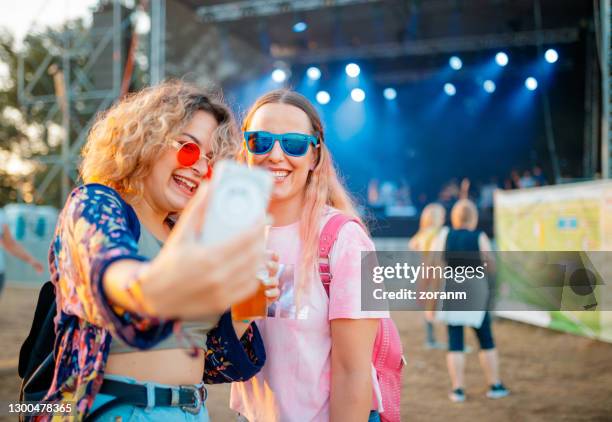 copines prenant le selfie sur le festival extérieur de musique de jour - couple concert photos et images de collection