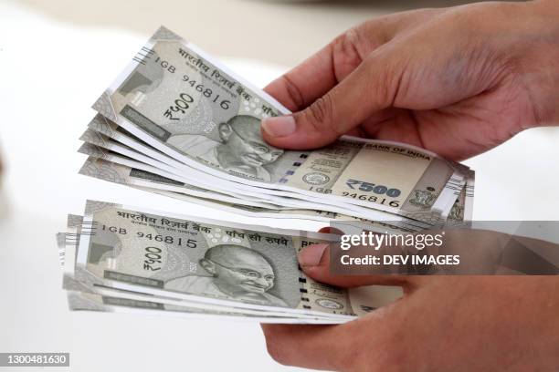 counting currency notes against white background - indian currency stock pictures, royalty-free photos & images