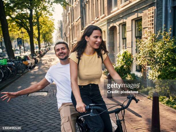 hitching a ride to happiness - amsterdam cycling stock pictures, royalty-free photos & images