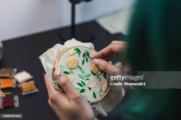 young woman's hands embroidering cloth in shape of lemon tree - embroidery frame stock pictures, royalty-free photos & images