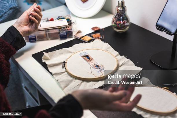 hands of female craftsperson embroidering cloth on table in studio - embroidery frame stock pictures, royalty-free photos & images