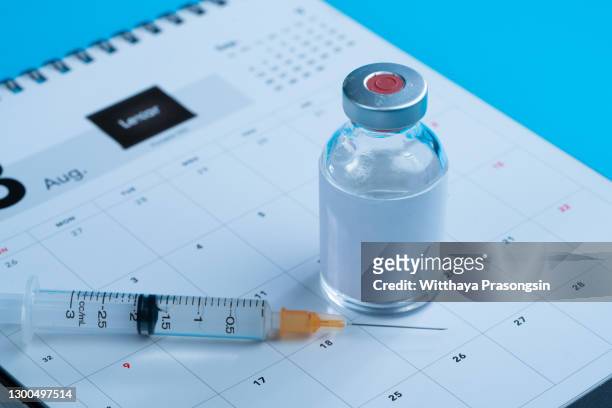 syringe and vaccine on a calendar - インフルエンザワクチン ストックフォトと画像