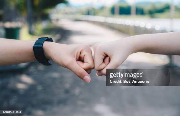 cropped shot of two people bump their fists together (or knuckle bump) for greeting. - punching stock pictures, royalty-free photos & images