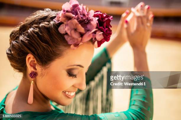 close-up of flamenco dancer wearing flowers clapping her hands - flamencos fotografías e imágenes de stock