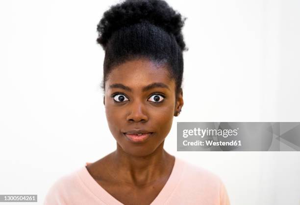 surprised woman staring while standing against white background - shocked woman stock pictures, royalty-free photos & images