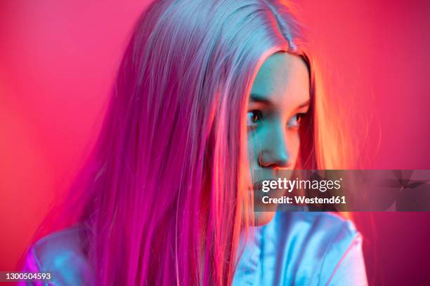 close-up of thoughtful young woman wearing wig against pink background - straight hair stock pictures, royalty-free photos & images