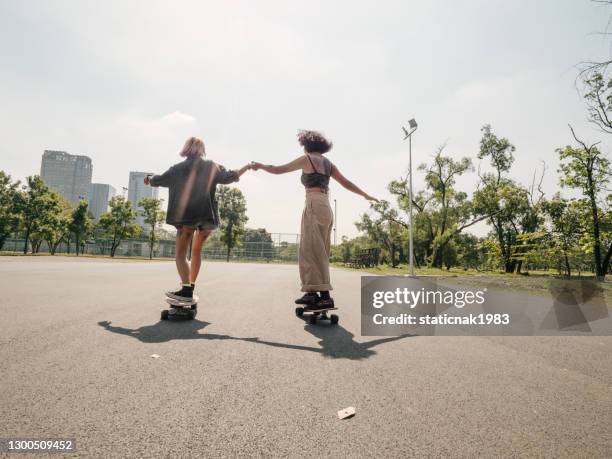 junge mädchen mit reiten longboard mit freunden - longboard stock-fotos und bilder