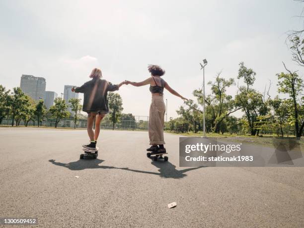 unga tjejer med ridning longboard med vänner - skateboard bildbanksfoton och bilder