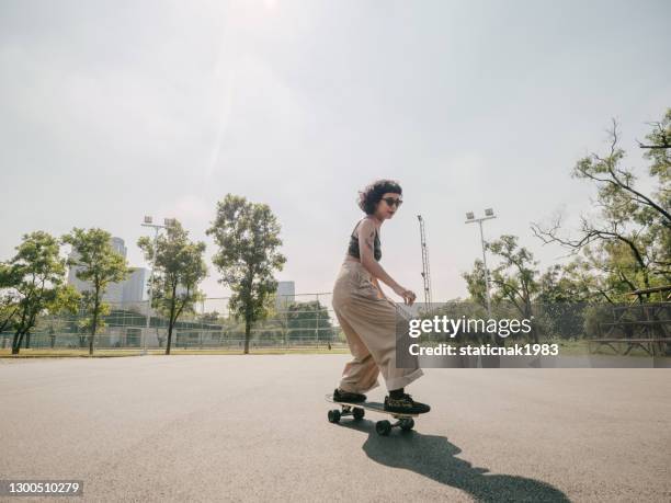 陽光明媚的日子，在公園裡玩滑板的少女。 - skateboard 個照片及圖片檔