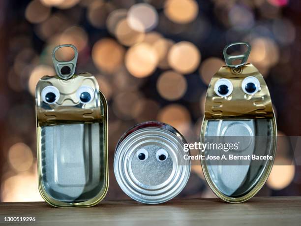 close-up of open fish canning cans forming a family with one child of three. - sardine can stock pictures, royalty-free photos & images