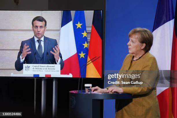 German Chancellor Angela Merkel and French President Emmanuel Macron, who is tuning in from Paris via video link, speak to the media following talks...