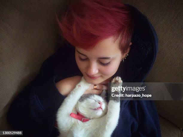 cat stretched out and sleeping on her owner. - lying on back girl on the sofa stock pictures, royalty-free photos & images