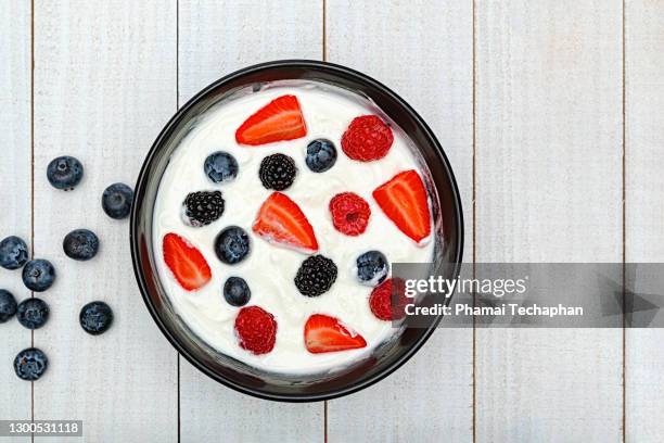 yogurt with mixed berry fruit - strawberry and cream stock pictures, royalty-free photos & images