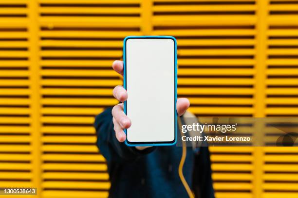 man showing smart phone white screen - demonstration photos et images de collection