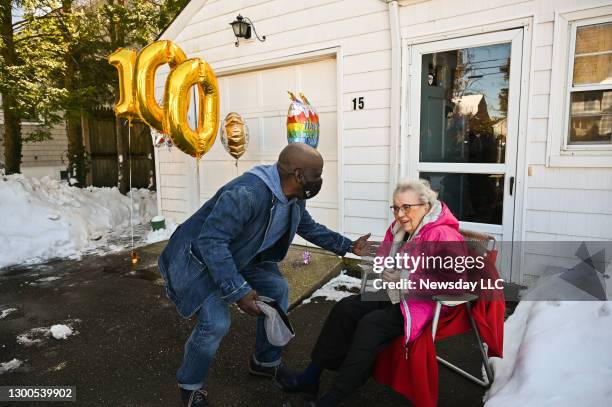 Ronald Worrell, a senior citizen aid with the Town of Huntington, left, sings a song to Alice Link, right, while celebrating her 100th birthday at...