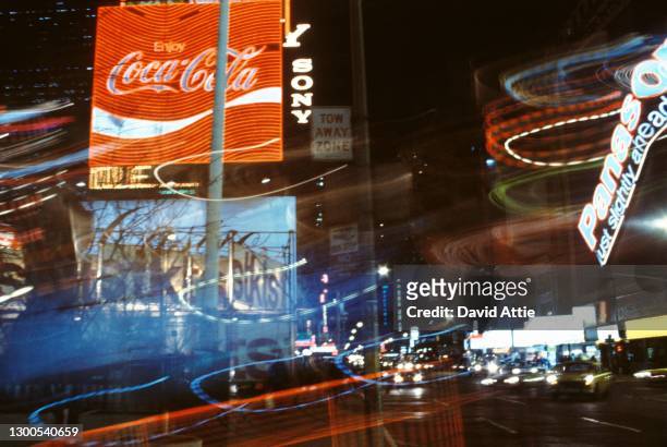 Photo montage of a Coca-Cola sign amid the bright lights and neon signs of Times Square in March 1962 in New York City, New York.