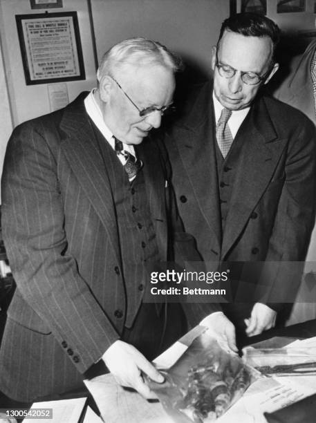 Warden James A. Johnston of Alcatraz Prison and James V. Bennett, director of the Federal Bureau of Prisons, examine the implement used by Paul...