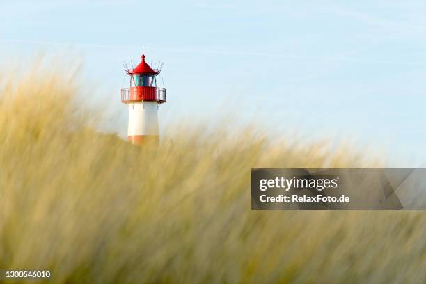 roter und witterungsgestreifter leuchtturm und klarer blauer himmel auf der insel sylt - sylt stock-fotos und bilder