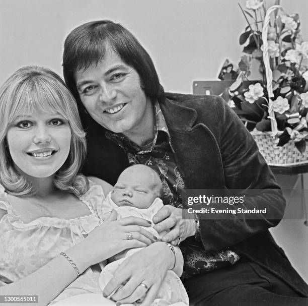 English disc jockey Tony Blackburn and his wife, actress Tessa Wyatt, with their new baby Simon, UK, 11th April 1973.