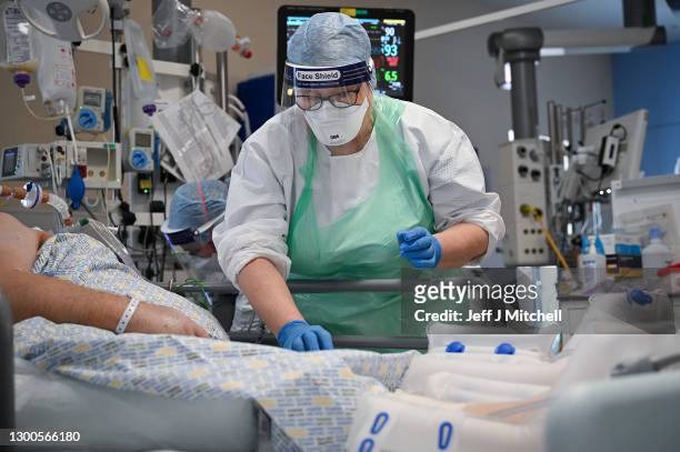 Member of staff at University Hospital Monklands attends to a Covid-positive patient on the ICU ward on February 5, 2021 in Airdrie, Scotland. The...