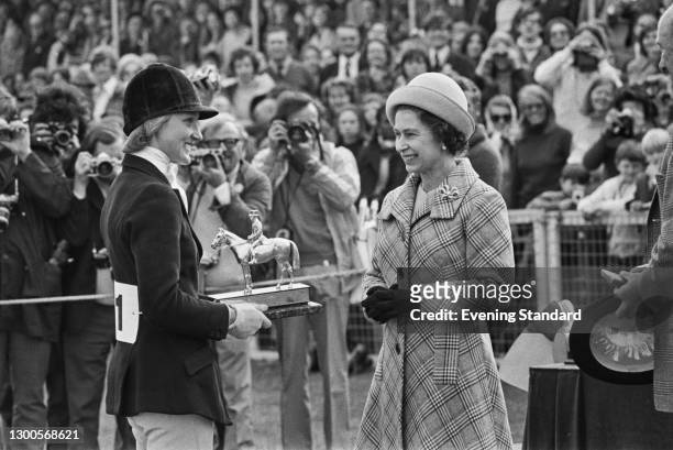 Queen Elizabeth II presents a trophy to British equestrian Lucinda Prior-Palmer at the Badminton Horse Trials, UK, April 1973.